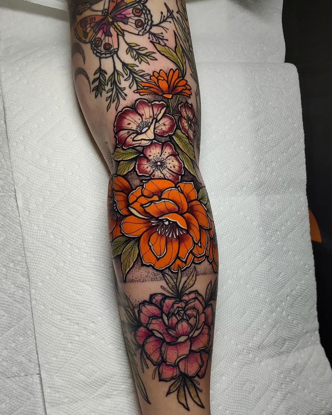 A botanical color tattoo sleeve of flowers and leaves by Naysla Droguett