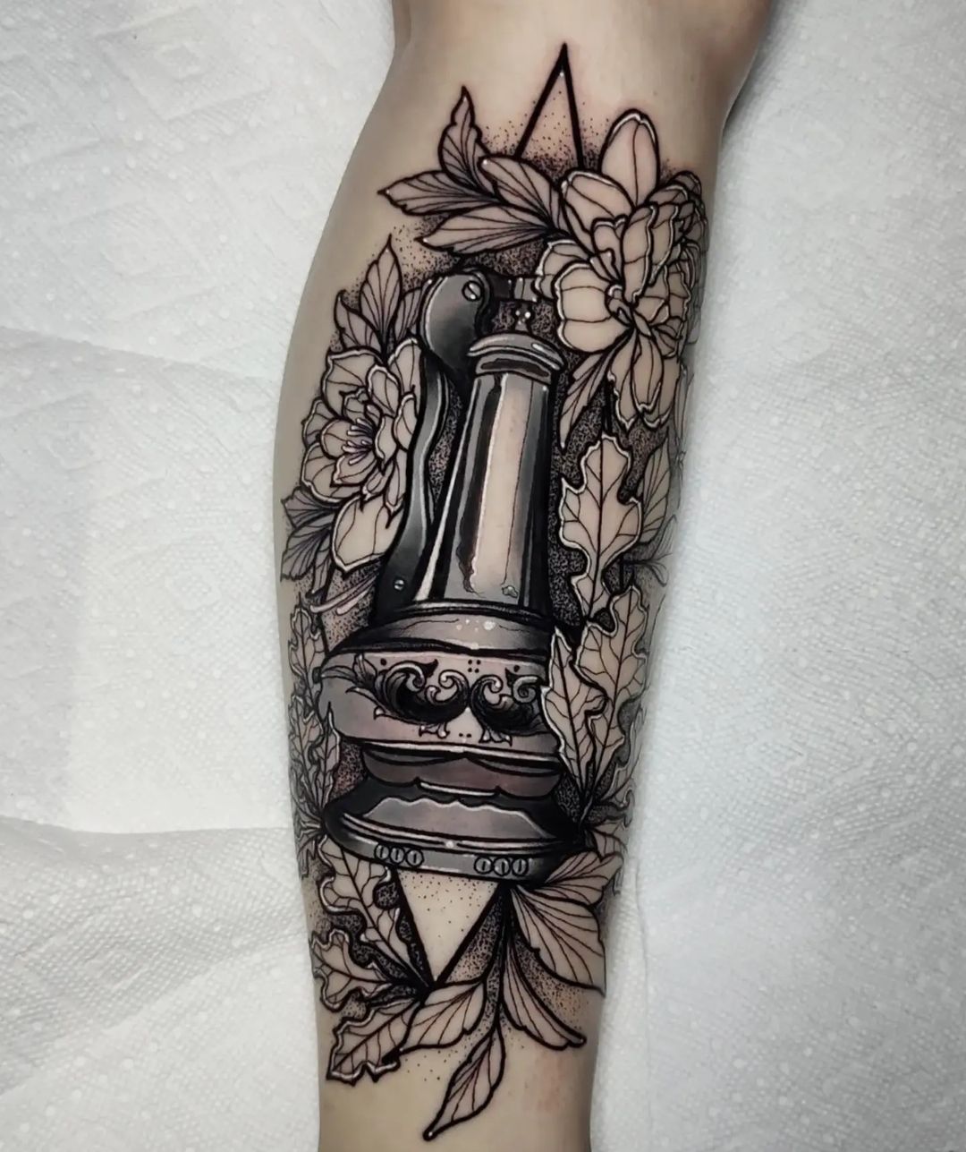 Lantern and lilies black and grey tattoo on the arm